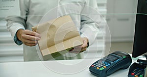 Pharmacy Drugstore Checkout Cashier Counter: Pharmacist and a Customer Using NFC Smartphone with Contactless Payment