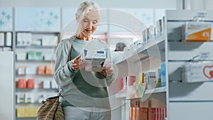 Pharmacy Drugstore: Portrait of a Beautiful Senior Woman Choosing to Buy Medicine, Drugs, Vitamins