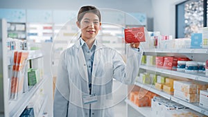 Pharmacy Drugstore: Portrait of Professional Asian Female Pharmacist Holding Showing Box of Pills