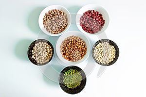 Phaseolus. Bright multi-colored beans, mung beans and chickpeas in ceramic cups.