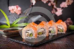 Philadelphia roll sushi with salmon, smoked eel, cucumber, avocado, cream cheese, red caviar. Sushi menu