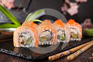 Philadelphia roll sushi with salmon, smoked eel, cucumber, avocado, cream cheese, red caviar. Sushi menu