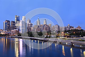 Philadelphia skyline illuminated and reflected into Schuylkill River at dusk