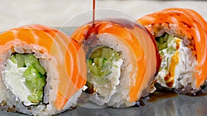 Philadelphia sushi rolls with salmon and cream cheese, close-up 4k footage, pouring soy sauce over premium Philadelphia