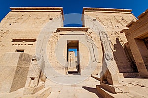 Philae Temple entrance guarded by two lion statues in Egypt