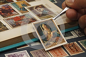 Philatelist looks at postage stamps