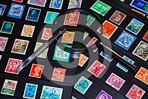 Philately magnifying glass and tweezers to see stamp collection