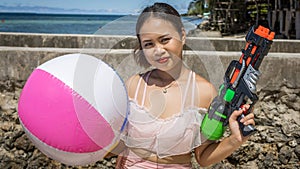 Philippine girl with a beachball and water gun