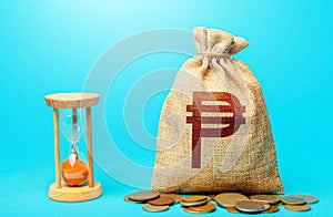 Philippine peso money bag and hourglass. Placing a deposit in the bank. Profitability and return on investment. Pension savings.