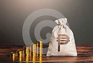 Philippine peso money bag and increasing stacks of coins. Savings. Rise in profits, budget fees. Raise incomes, increase salaries