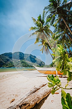 Philippines beach landscape - Local banca boat under palm trees at Corong Corong beach in El Nido, Palawan island