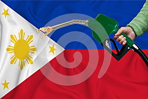 PHILIPPINES flag Close-up shot on waving background texture with Fuel pump nozzle in hand. The concept of design solutions. 3d