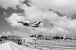 Philipsburg, Sint Maarten - February 13, 2016: plane low fly over maho beach. Jet flight land on cloudy blue sky