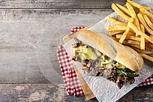Philly cheesesteak sandwich on wooden table. Copy space