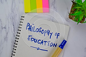 Philosophy of Education write on a book isolated on Wooden Table