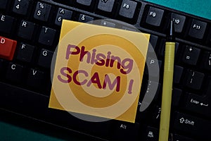 Phising Scam! write on a sticky note isolated on Office Desk photo