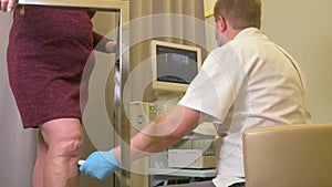 phlebologist or vascular surgeon examines the varicose veins of the lower extremities of a patient in a modern