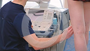 A phlebologist or vascular surgeon performs an ultrasound examination of the patient's veins.