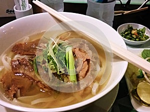 Pho soup dish consist of Vermiceli and meat on white bowl