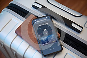 Phone with airplane ticket application airlines on screen suitcase airport