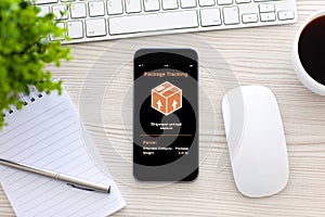 Phone with app tracking delivery package screen in office