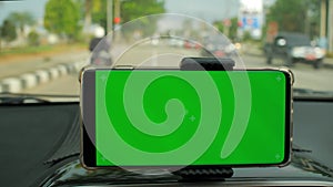 Phone as navigation device, blank green screen smartphone mock up template on car dashboard