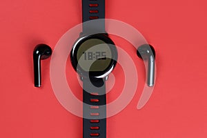 Phone and Bluetooth wireless headphones on red background