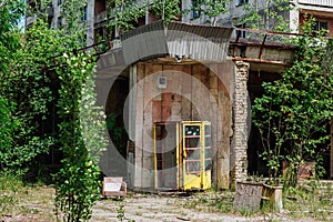 Phone box near abandoned building in centre of ghost town Pripyat Chornobyl Zone photo