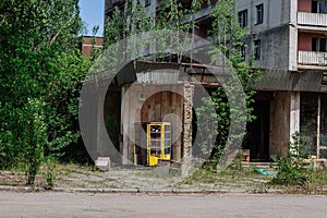 Phone box near abandoned building in centre of ghost town Pripyat Chornobyl Zone photo