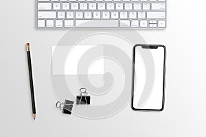 Phone and business card mockup on white office desk