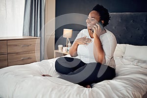 Phone call, happy and black woman on bed in home, talking and communication in the morning. Smartphone, conversation and
