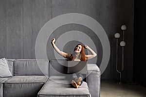 Phone conversation. Confident young woman sit on couch talk speak communicate by telephone from home holding device at ear. Teen