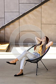 Phone conversation. Confident young woman sit on couch talk speak communicate by telephone from home holding device at ear. Teen