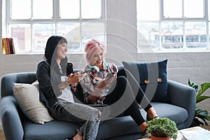 Phone, education and students with women friends sitting on a sofa in the campus breakroom at college. Social media photo