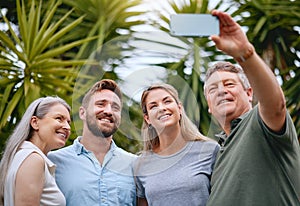 Phone, family and selfie with a man, woman and inlaws posing for a picture together in a garden or yard outdoor. Mobile