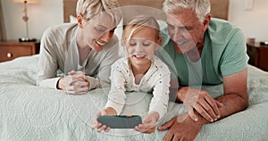 Phone, games and a girl with her grandparents on a bed in the home for playing together or bonding. Love, kids or family