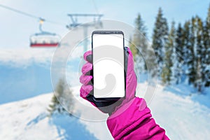 Phone in girl hand with glove on a ski lift. Isolated screen for mockup