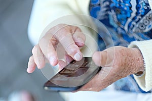 Phone in the hands of an elderly woman