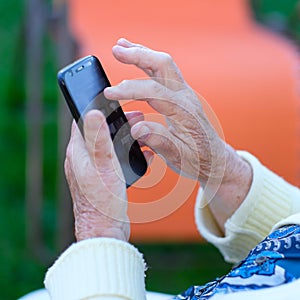 Phone in the hands of an elderly woman