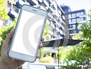 Phone in hands with an isolated screen on the background of the building hotle