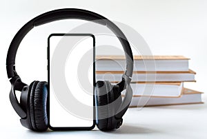 Phone and headphones in the background of books. concept choice of technology or classics.
