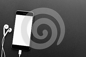 Phone and headphones on table top view with copyspace