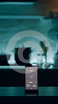 Phone with intelligent software placed on table in kitchen with nobody in