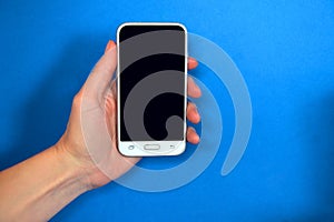 Phone in the left hand on a blue background.