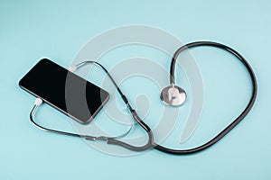 Phone with listening stethoscope on blue background