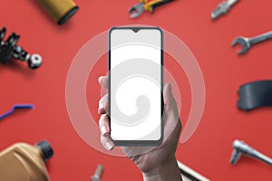 Phone mockup with isolated screen for app or web page promotion, backgrounded by car parts and tools