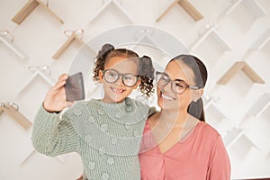 Phone, mother and child take a selfie at optometrist in new glasses after shopping for a family discount. Smile, mom and