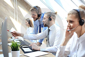 Phone operator working at call centre office helping his colleague