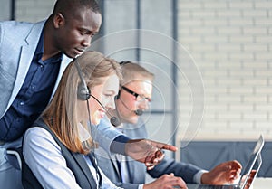 Phone operator working at call centre office helping hiss colleague