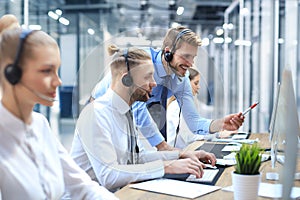 Phone operator working at call centre office helping hiss colleague.